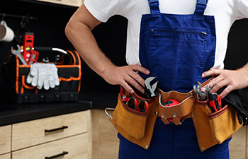 Professional plumber with tool belt indoor