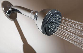 Shower head in bathroom spraying stream of water