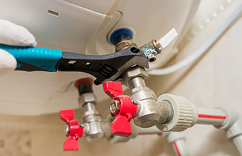 Close-up of female hand adjusting temperature of water heater